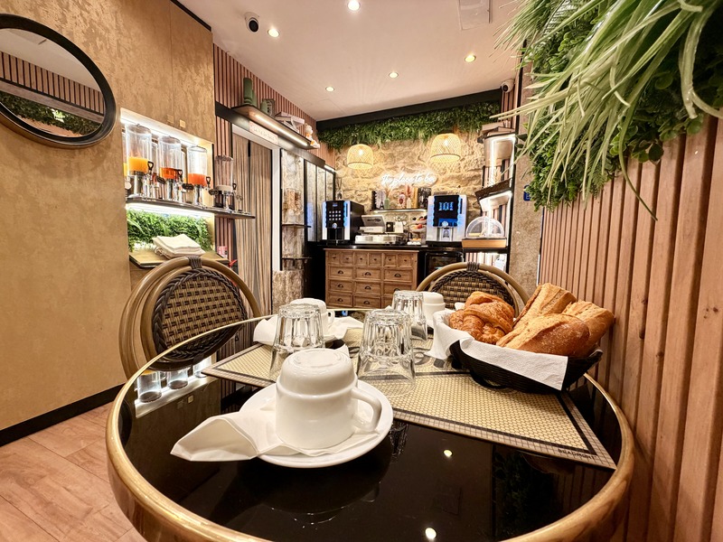 Una mesa puesta con cruasanes y, al fondo, el bufé