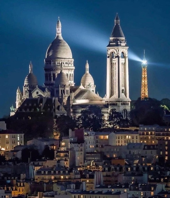 El Sacré-Cœur iluminado de noche, con la torre Eiffel al fondo