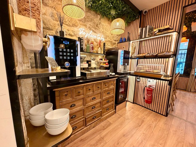 The buffet and its coffee machines under the illuminated sign The place to be