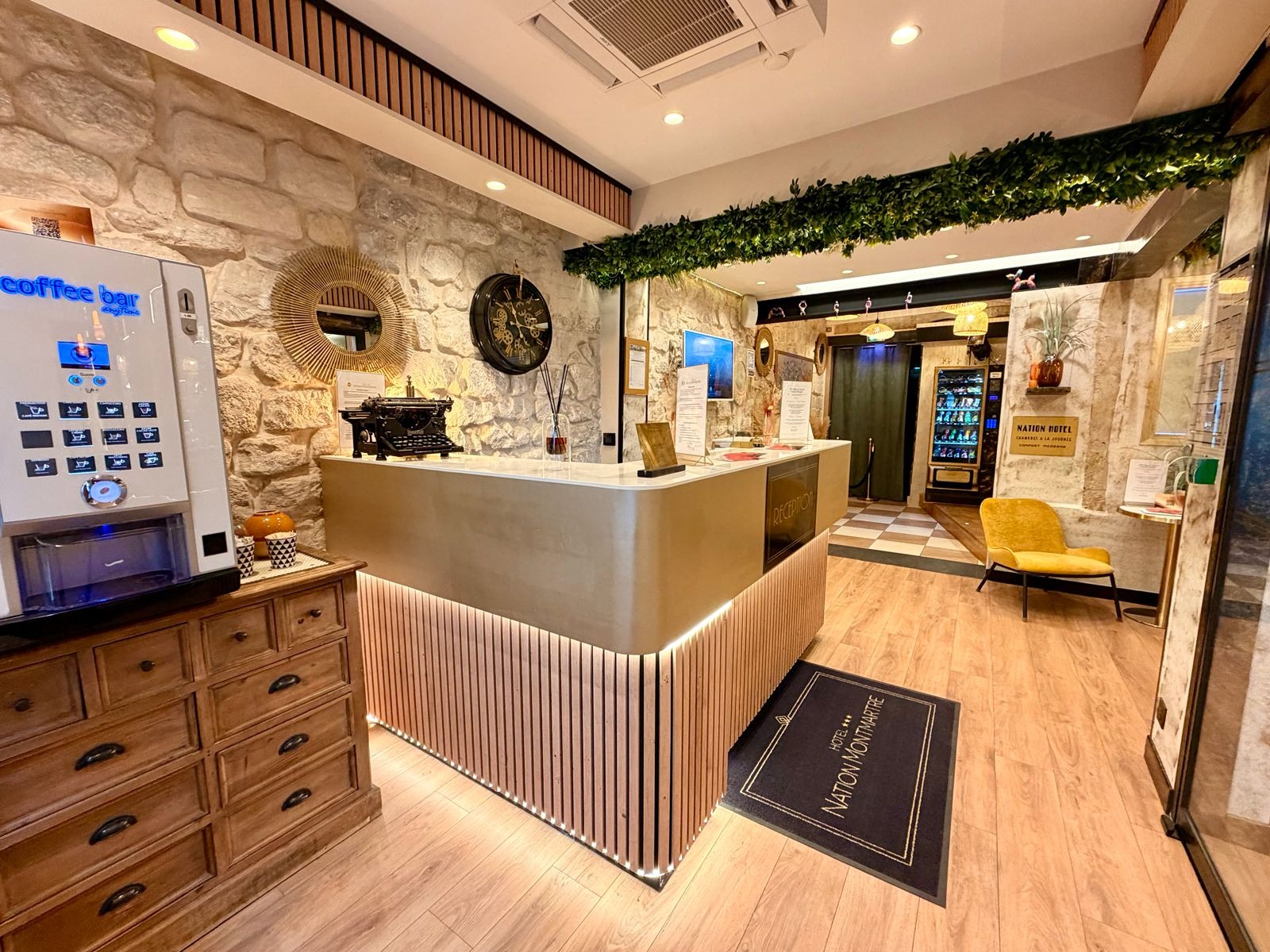 Die Rezeption des Hôtel Nation Montmartre mit ihrem beleuchteten Tresen und der Lobby